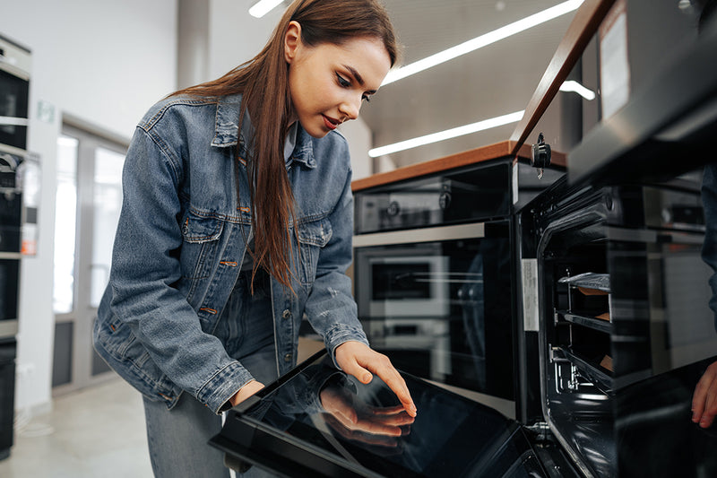 Woman looking an used appliance in Edmonton